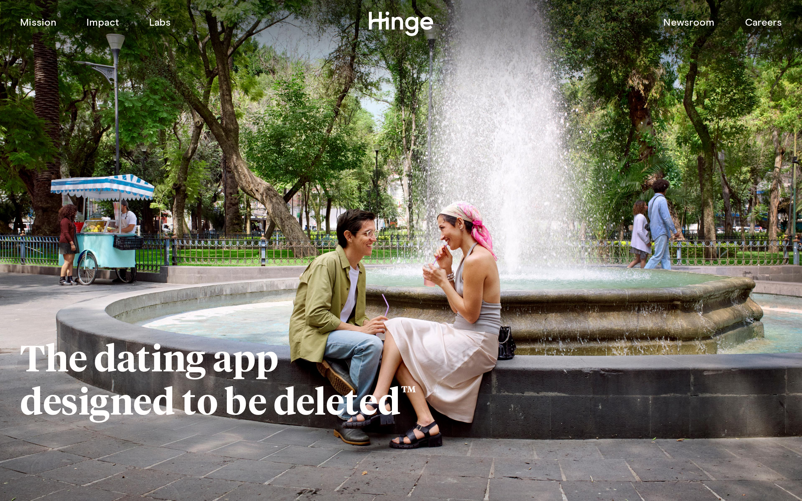 Hinge homepage showing the tagline The dating app designed to be deleted over a photo of a couple talking beside a fountain